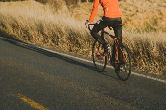 cyclist riding on the side of the road
